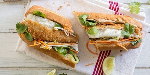Vietnamese-style Banh Mi using sealords frozen wholemeal hoki fillets, served on a white chopping board filled with salad, carrots, lettuce