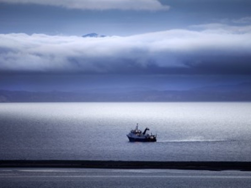 fishing boat headed out to sea, cloudy day and a calm ocean, Nz