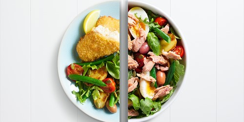Split plate showing Sealord crispy hoki fillet with greens and roast potatoes on one side, and classic tuna Niçoise salad with eggs, beans, and tomatoes on the other.