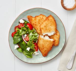 Crumbed Smooth Dory fillets served on a plate with a fresh garden salad of spinach, cherry tomatoes, red onion, and feta.