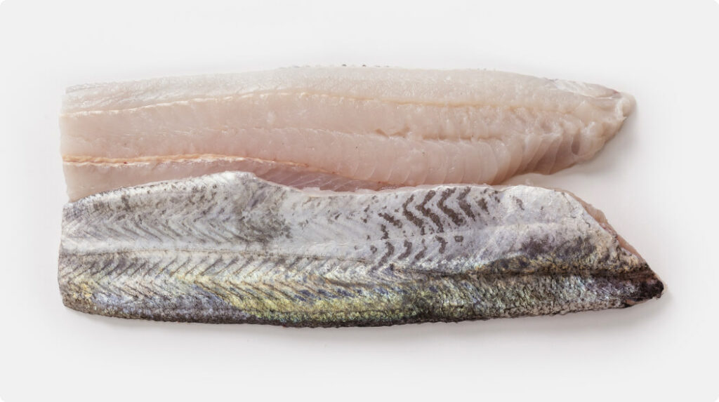 Pair of Hoki trimmed fillets (TRF), one skin-on and one skinless, showing clean cuts and firm texture. Ideal for foodservice or further processing.
