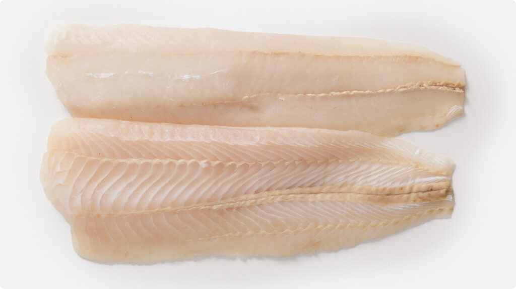 Two trimmed and skinned Hoki fillets (TSK), boneless and pale pink-white in colour, showing clean texture and ready for cooking or commercial processing.