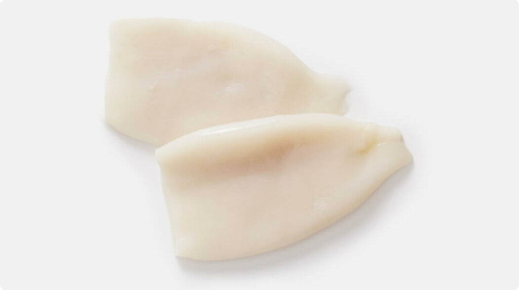 Two cleaned squid tubes with smooth, white flesh, displayed on a white background.