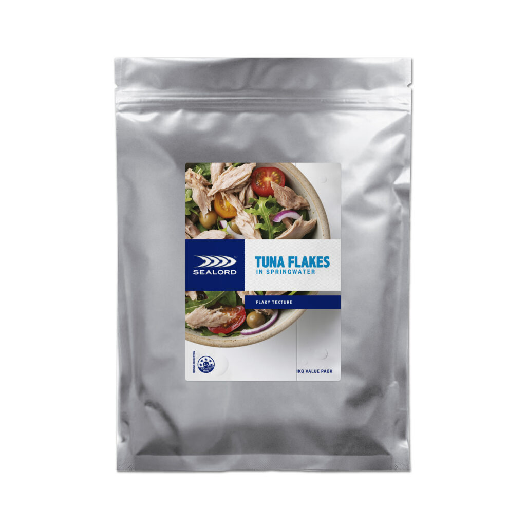 Sealord Tuna Flakes in Springwater 1kg value pack, silver pouch with a label featuring a fresh salad image and branding. Labeled “flaky texture.”