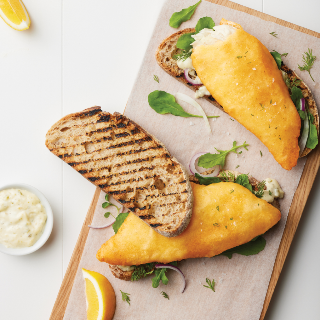 Golden battered Smooth Dory fillets served on toasted sourdough with leafy greens, red onion, and tartare sauce.